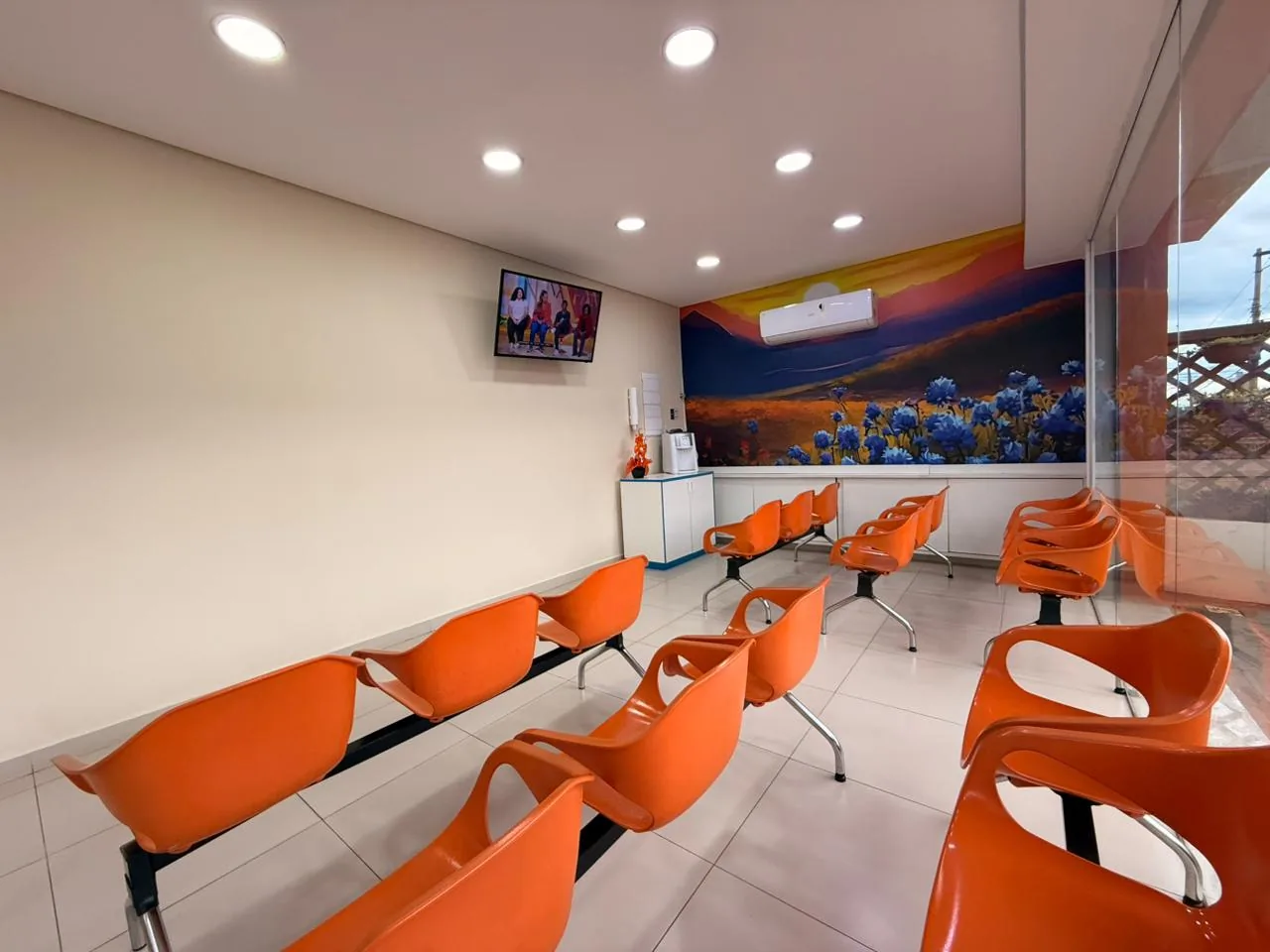 Sala de espera da Innovah com cadeiras laranja e mural decorativo